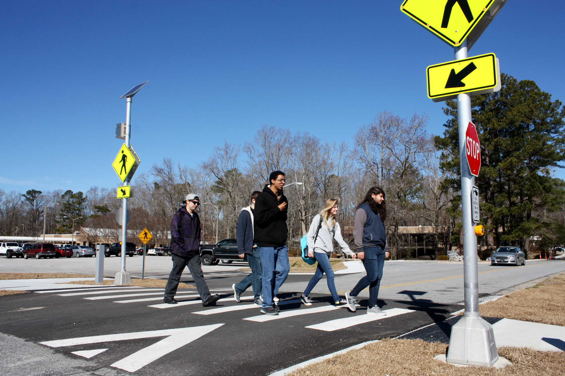 Five students cross at a protected intersection.