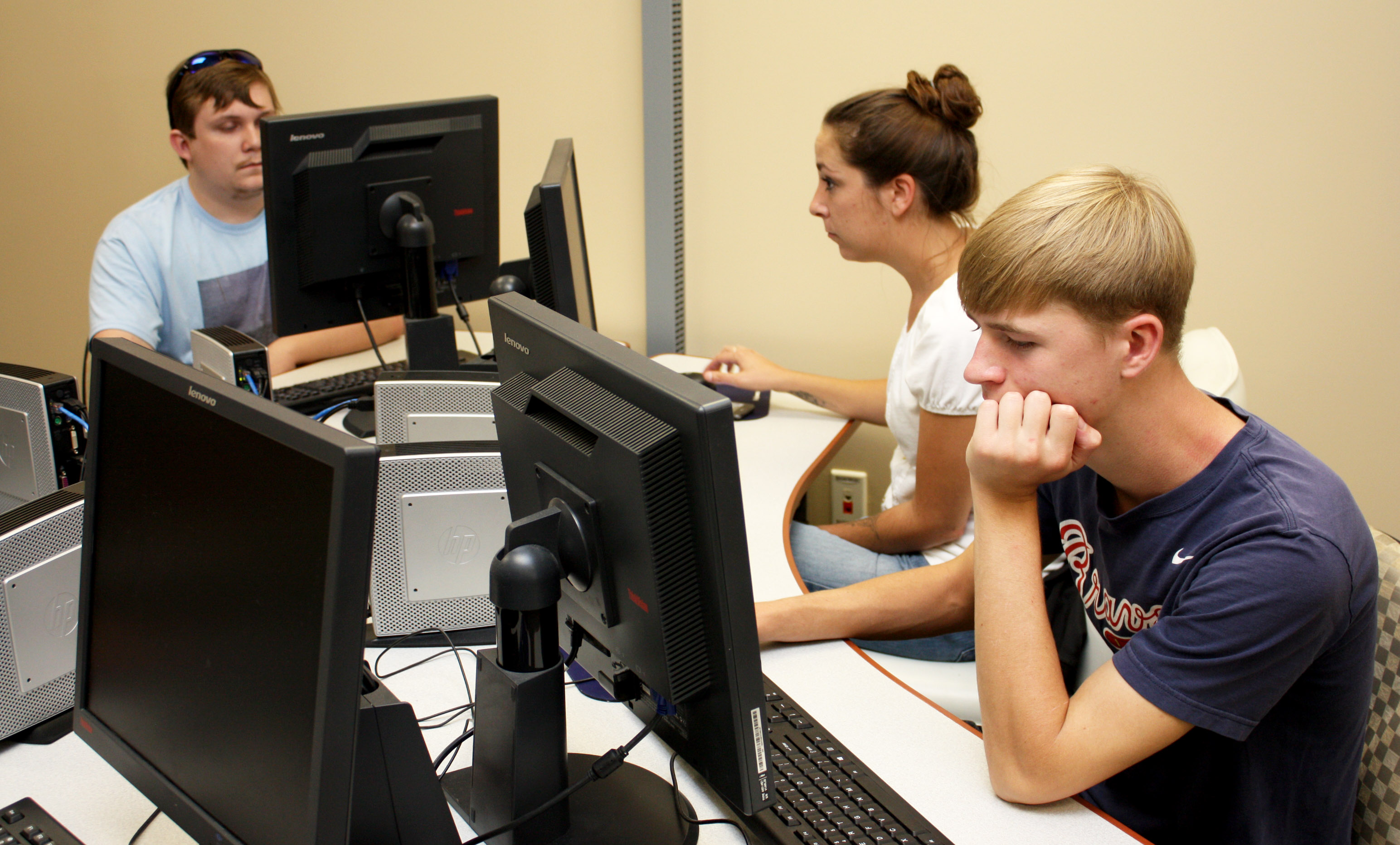 Three students looking at computers.