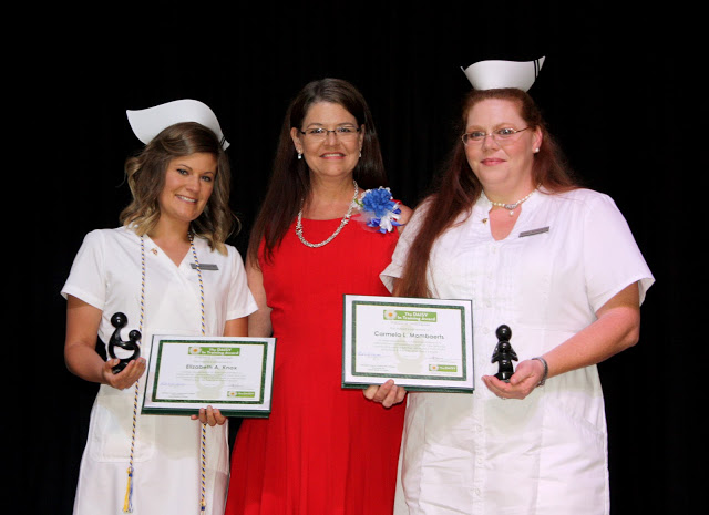 Photo of two graduating nurses and instructor.  