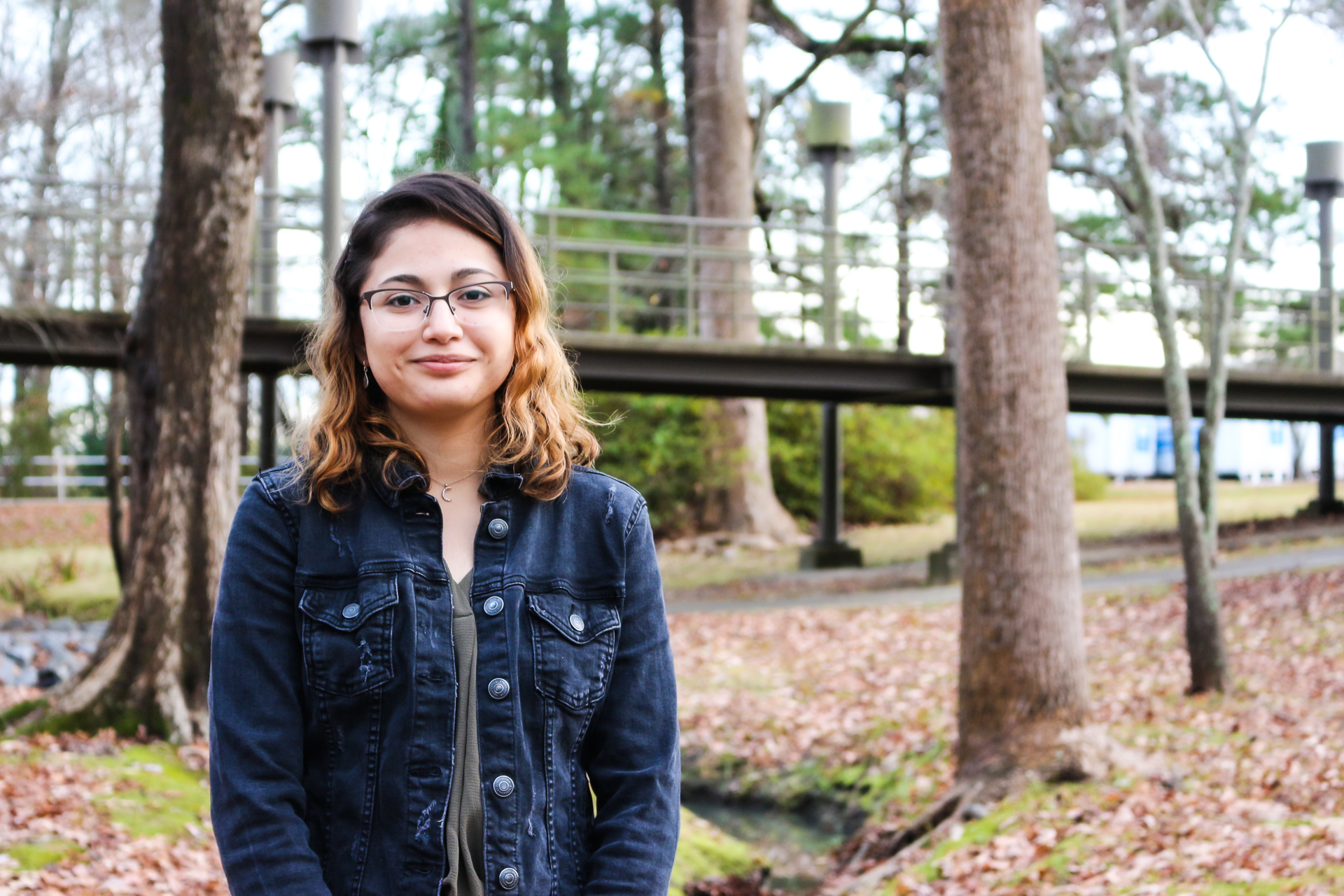A student in front of trees and walkway