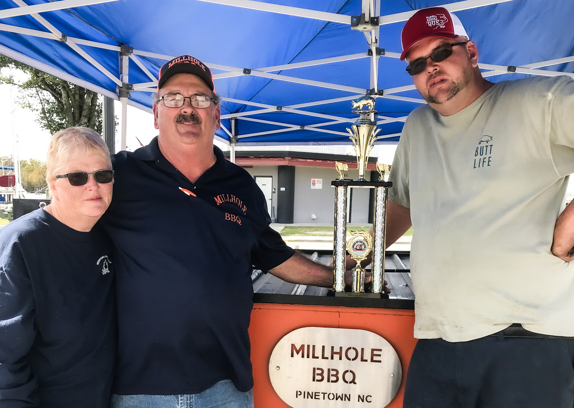 People with a trophy and the words Millhole BBQ Pinetown NC.