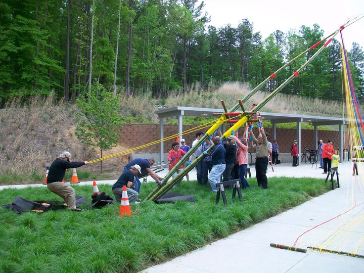 people lifting a bamboo sculpture