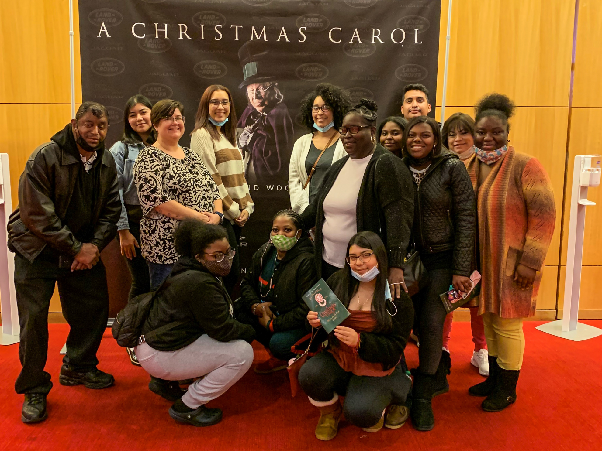 a group in front of a poster for A Christmas Carol