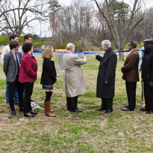 A line of people cutting a ribbon