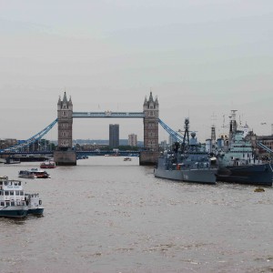 Photo of metropolitan city in London a ocean view of large bridge, various boats , cruise ships, cargo ship, tourist boats