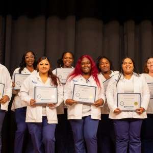 Women holding certificates on stage