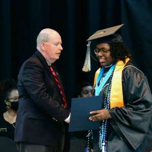 2 people shaking hands with diploma