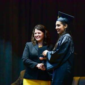 2 women on stage with certificate