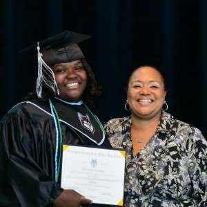 2 people smiling with a diploma