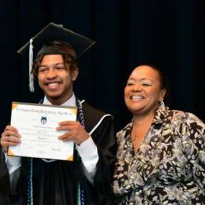 Man & woman smiling with a diploma