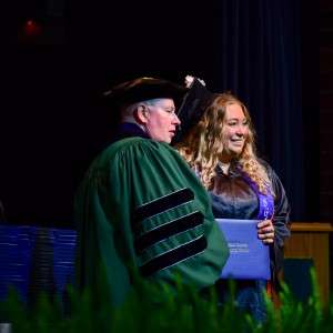 2 people on stage with certificate