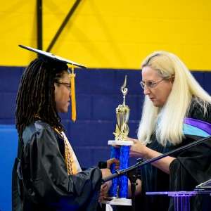 Person receiving a trophy from another