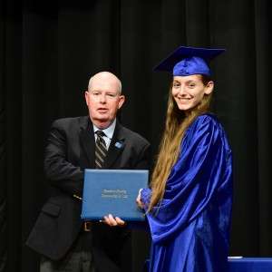 2 people on stage with a diploma