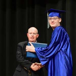 2 men on stage shaking hands