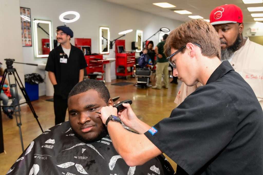 Man shaving anothers face