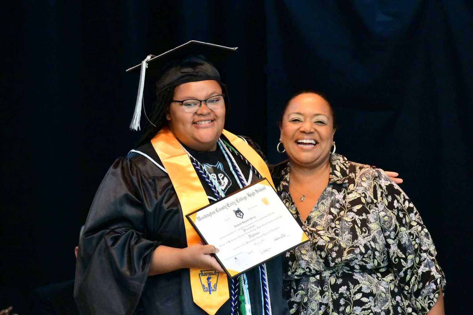 2 People on stage with diplomas