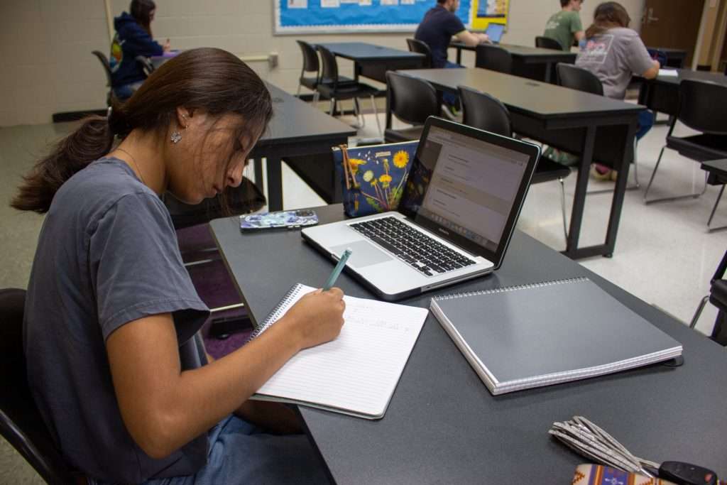 Student with a laptop in a classroom
