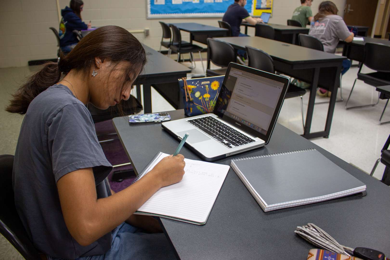 Student with a laptop in a classroom