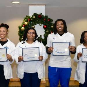 4 people holding certificates
