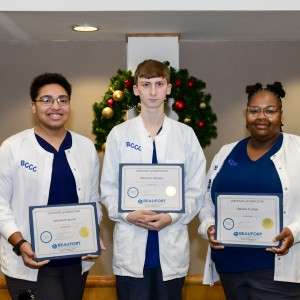 3 students holding certificates
