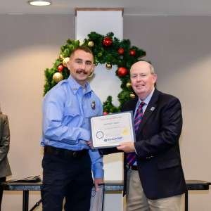 2 men shaking hands holding certificates