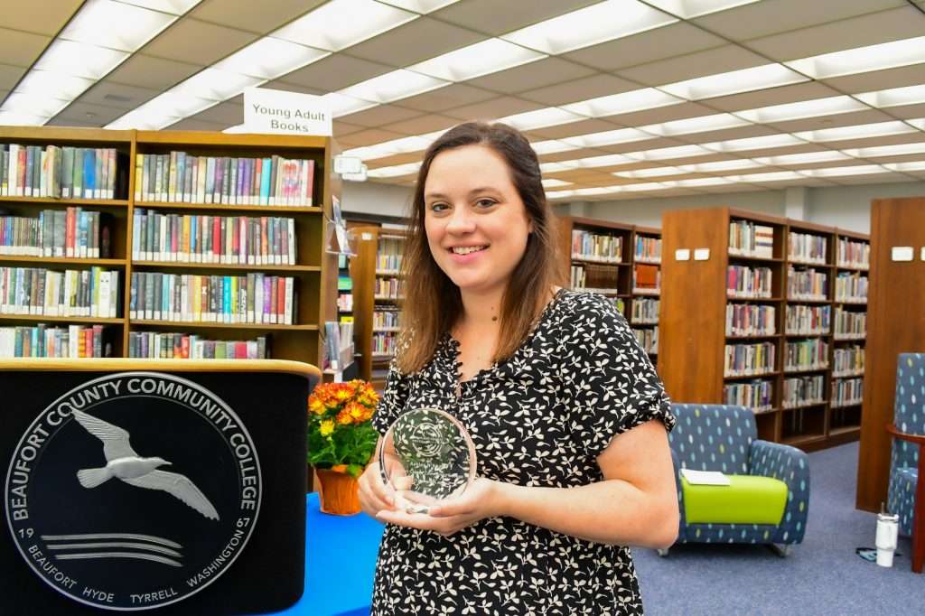 Woman by podium holding award