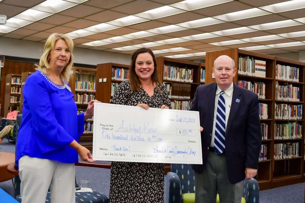 3 people and large check