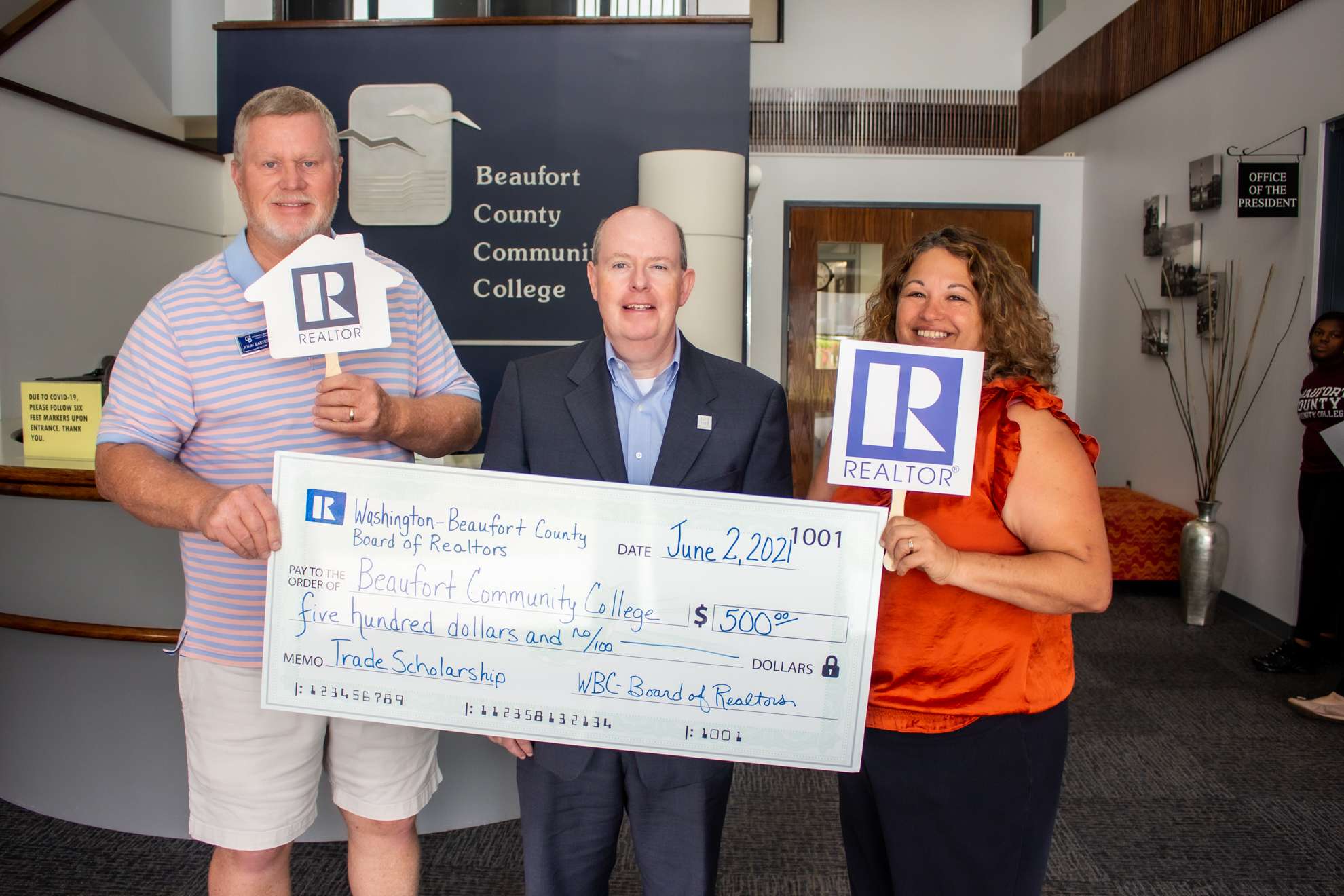 three people and a big check
