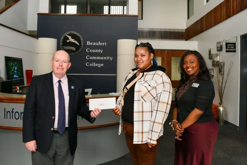 People handing an award to student