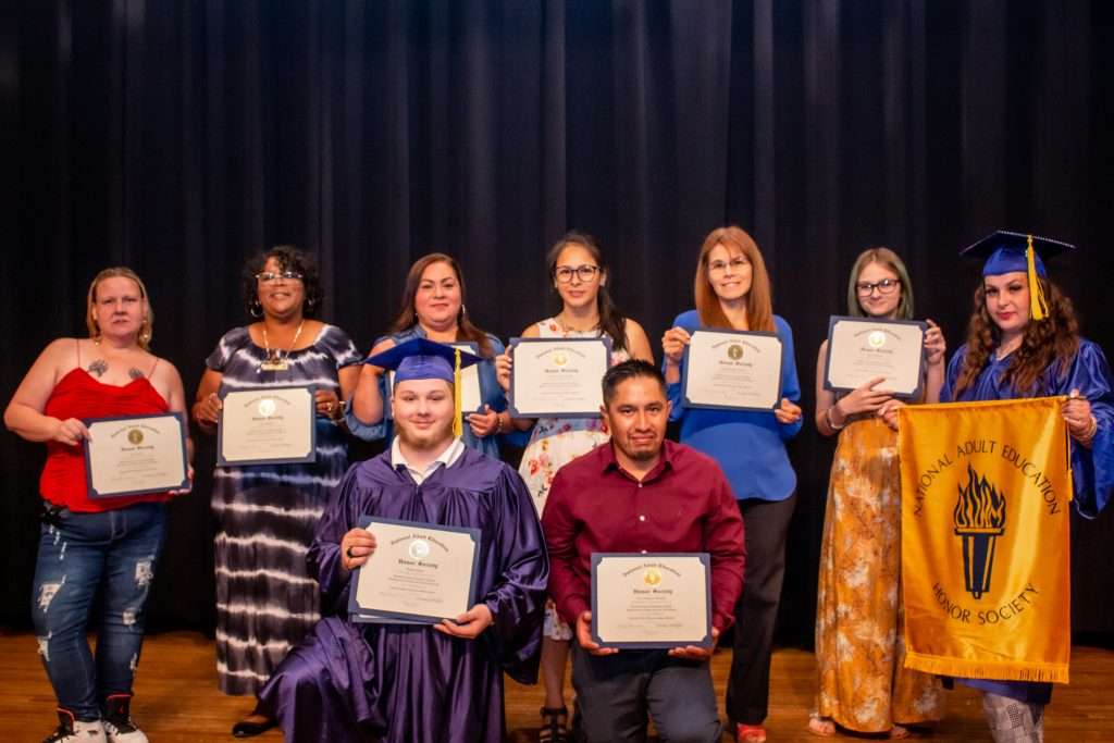 People on stage with certificates.