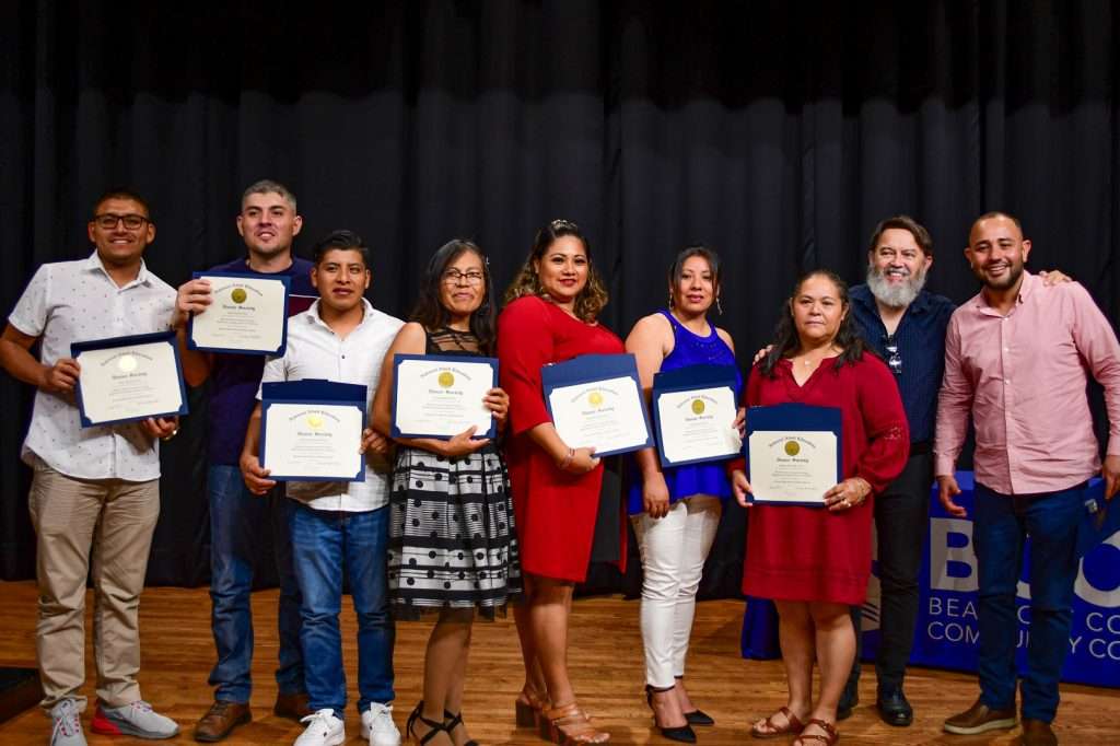 People on stage with certificates