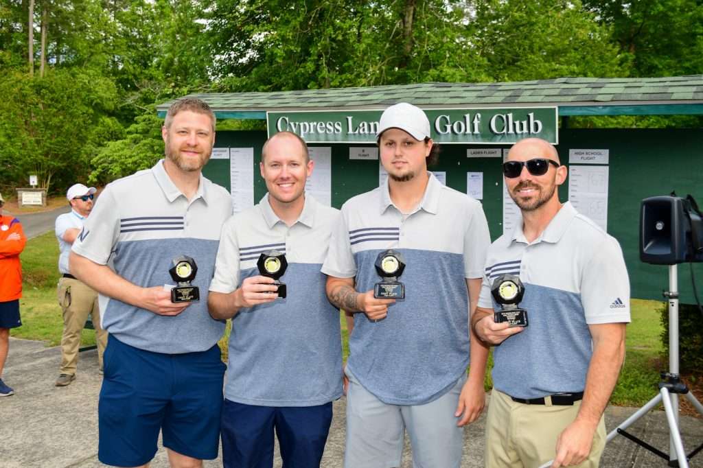 4 men holding trophies