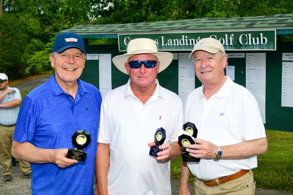 3 men holding trophies