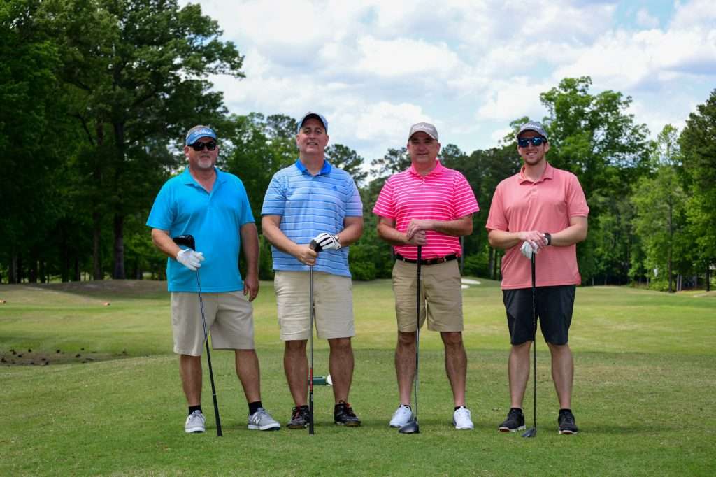 4 people on a golf course