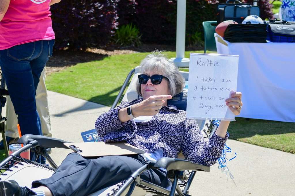 personin chair holding sign