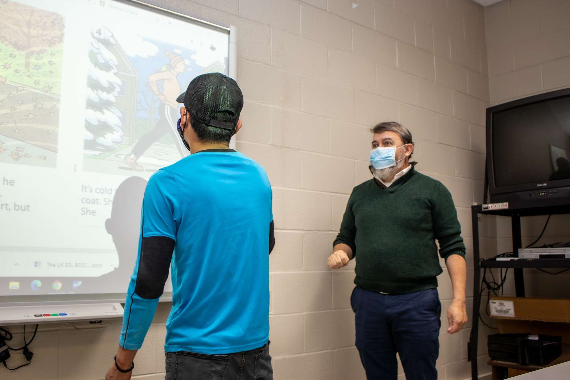a student at a board with a teacher.