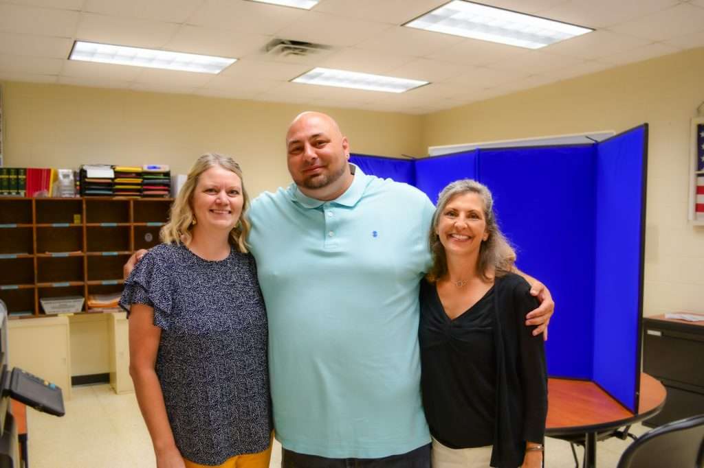 Man with arms around 2 women