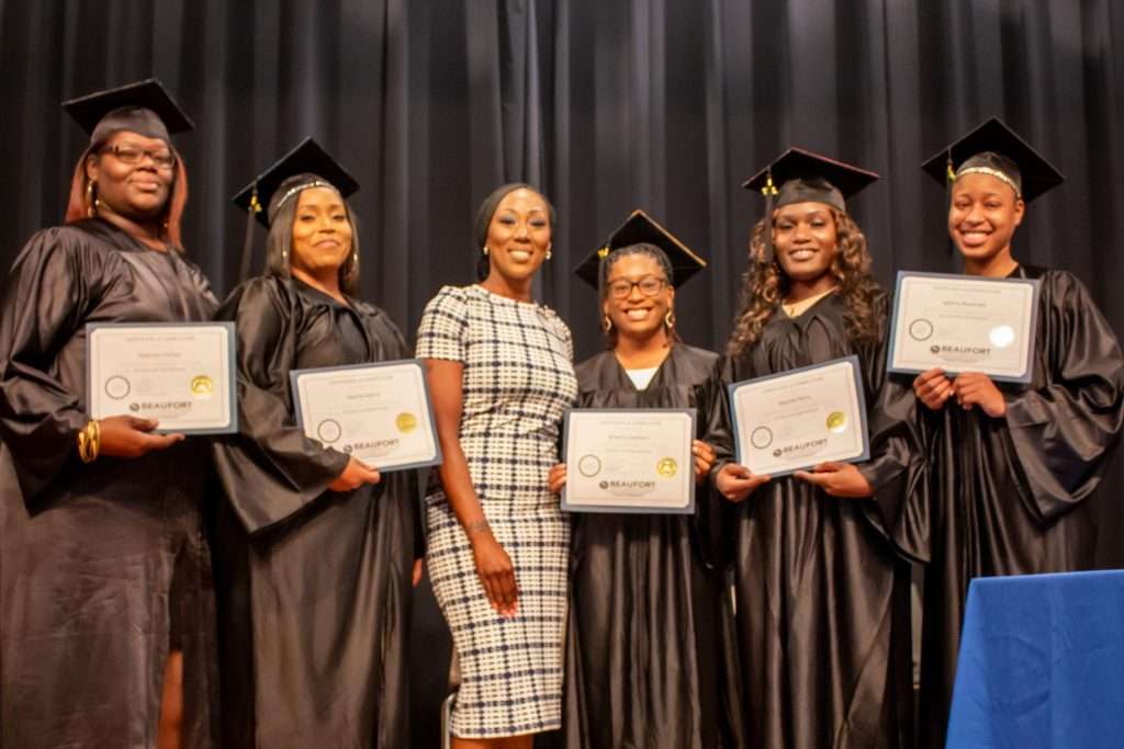 Women on stage with certificates