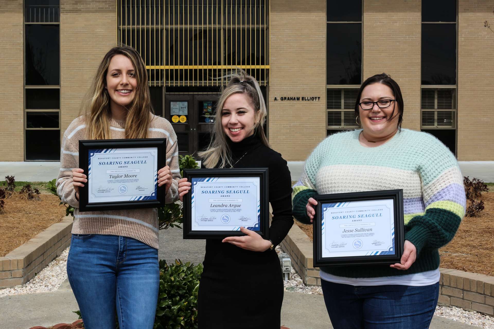 Three people with plaques