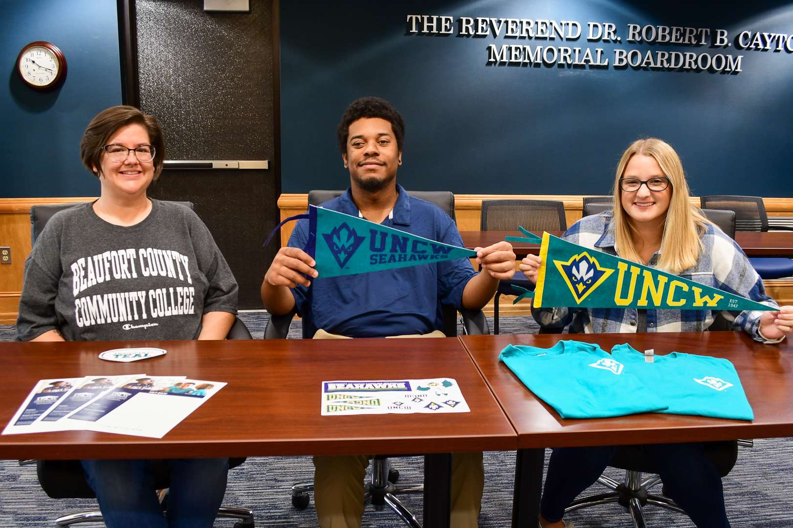 Students displaying banners for universities they are transferring to.