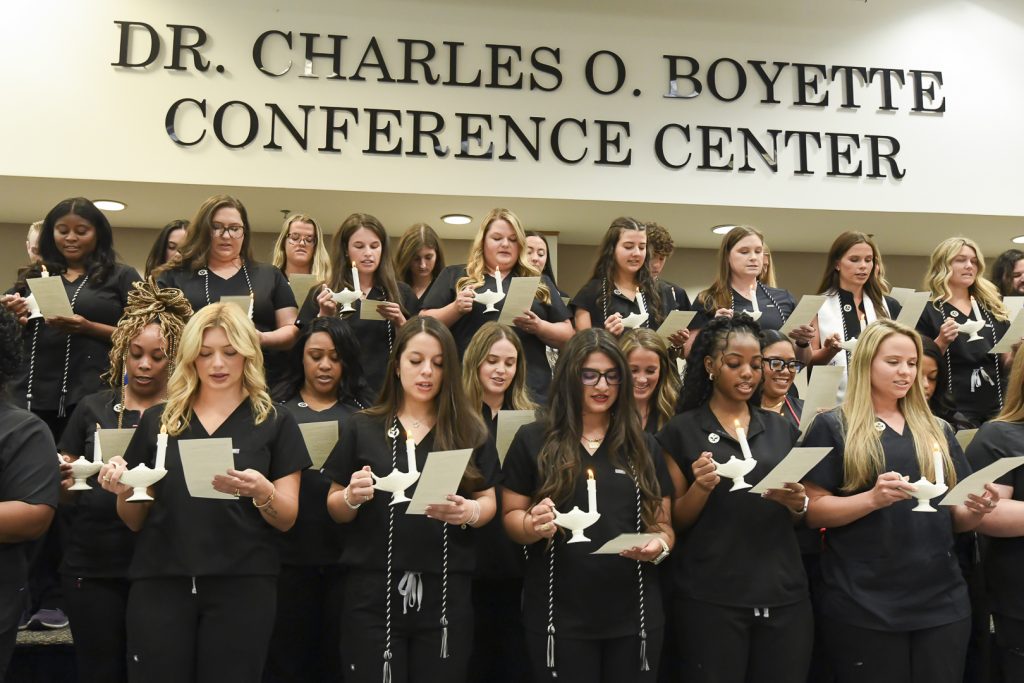 Large group of people in black with text Dr. Charles O Boyette Conference Center