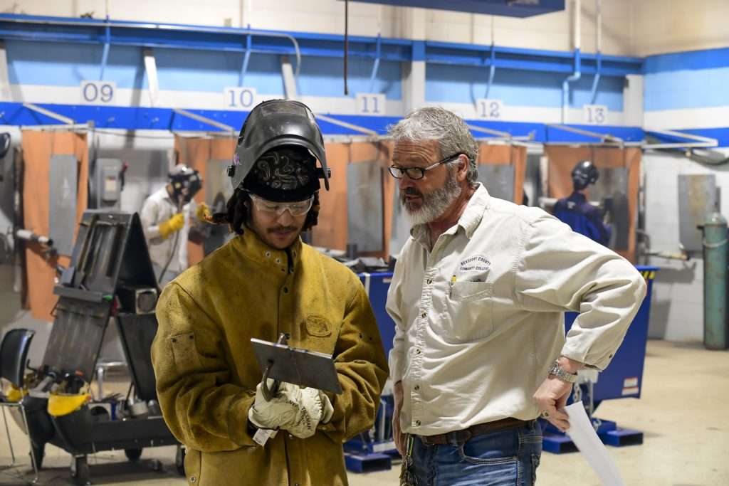 two people looking at a weld