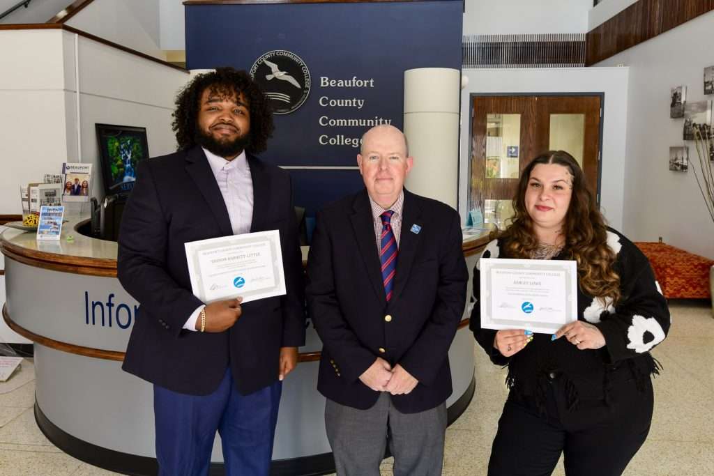 three people two holding awards