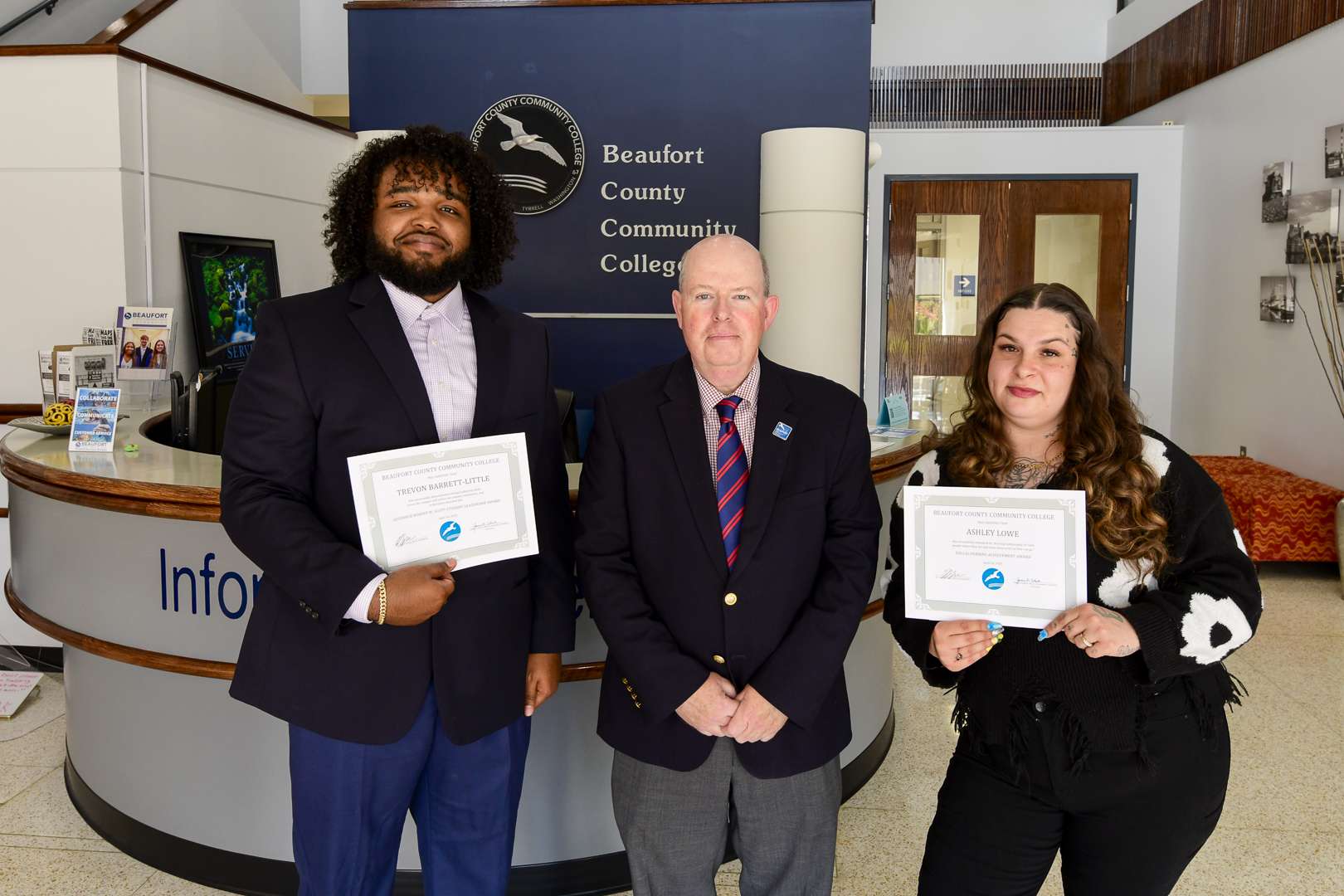 three people two holding awards