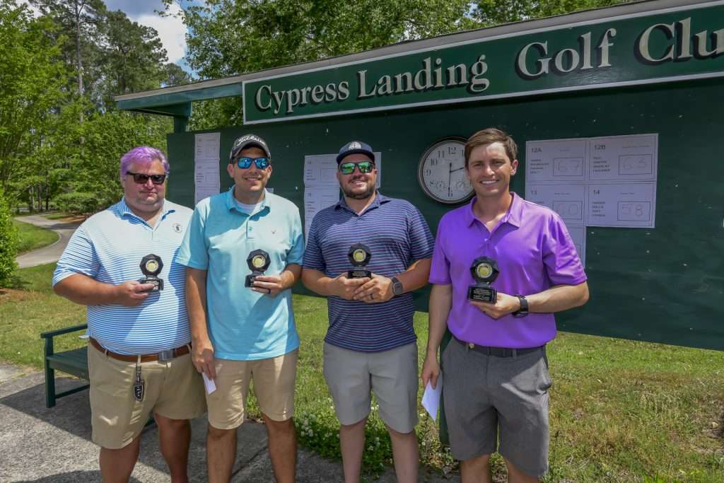 four people holding trophies
