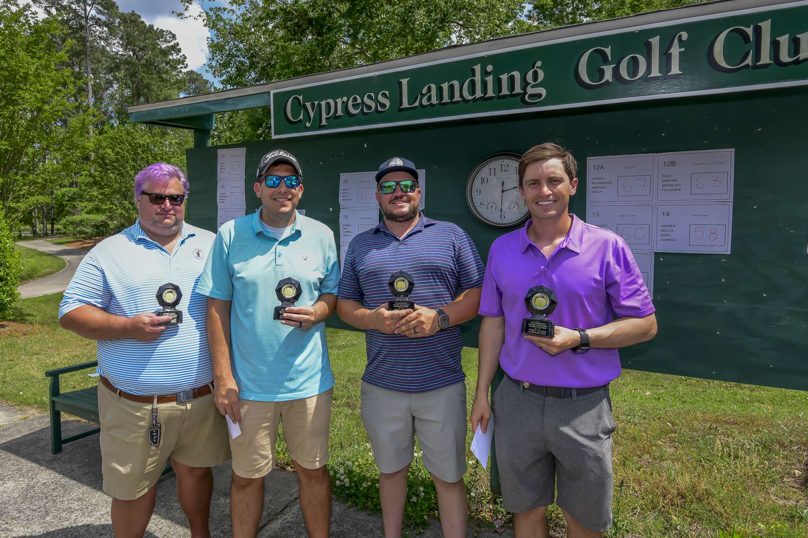 four people holding trophies