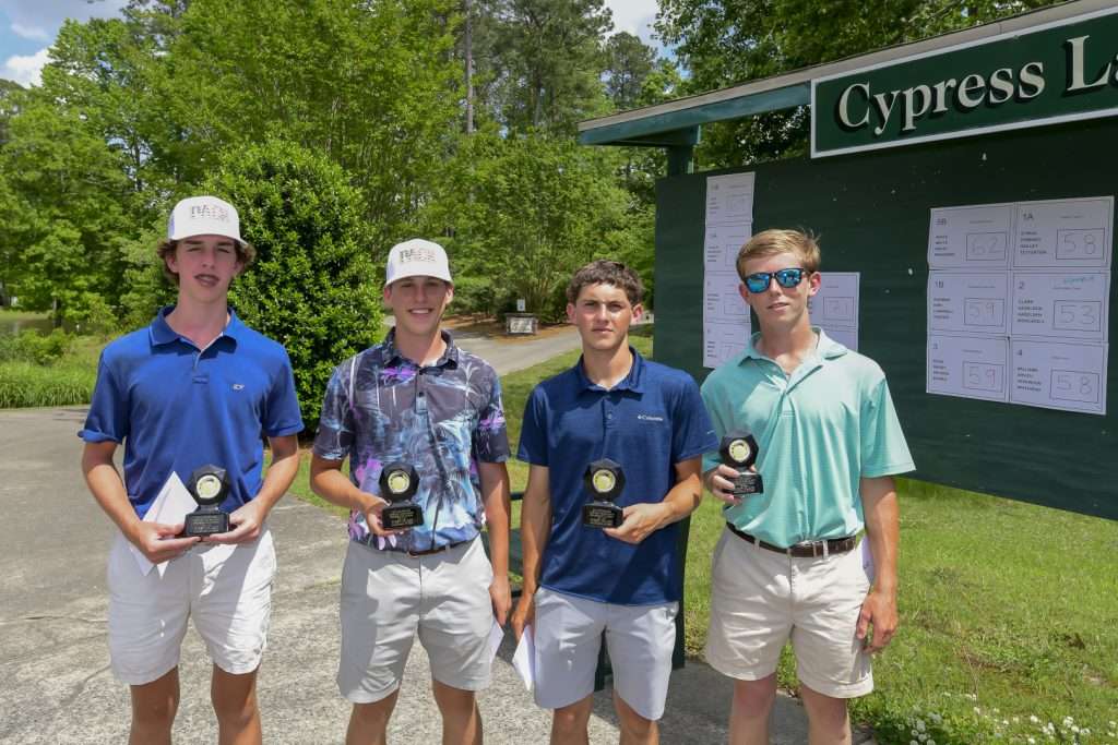 four people with trophies