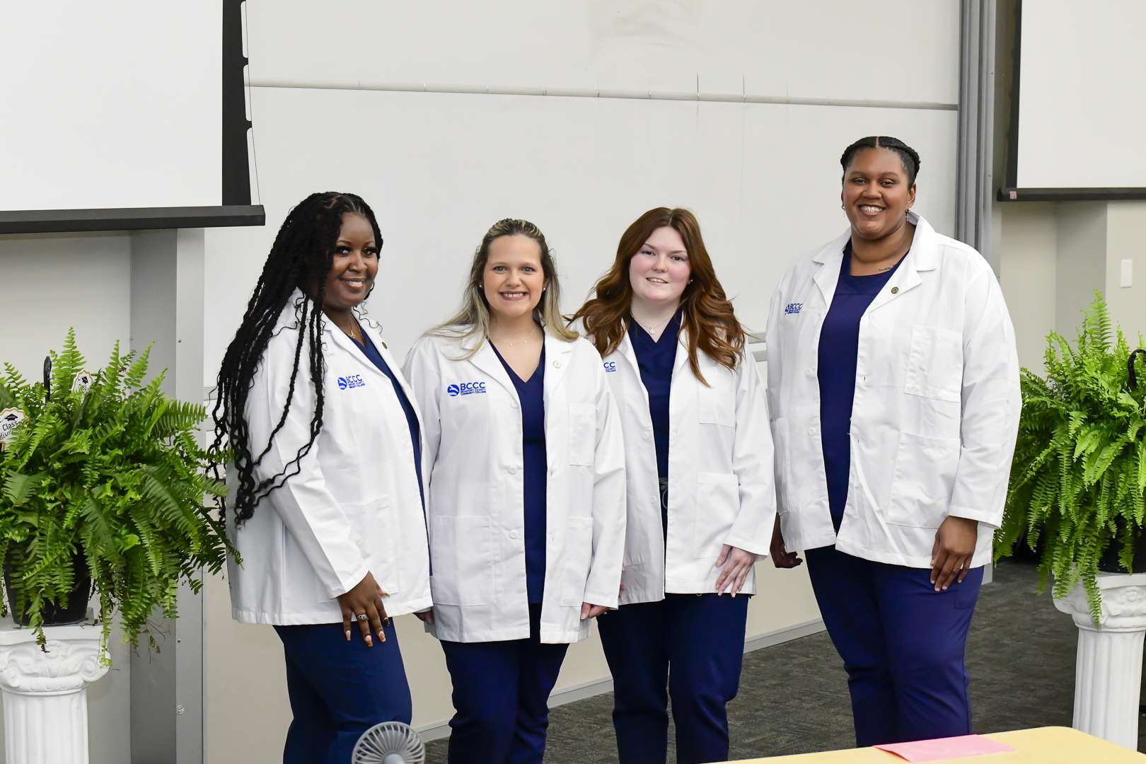 four people in white coats