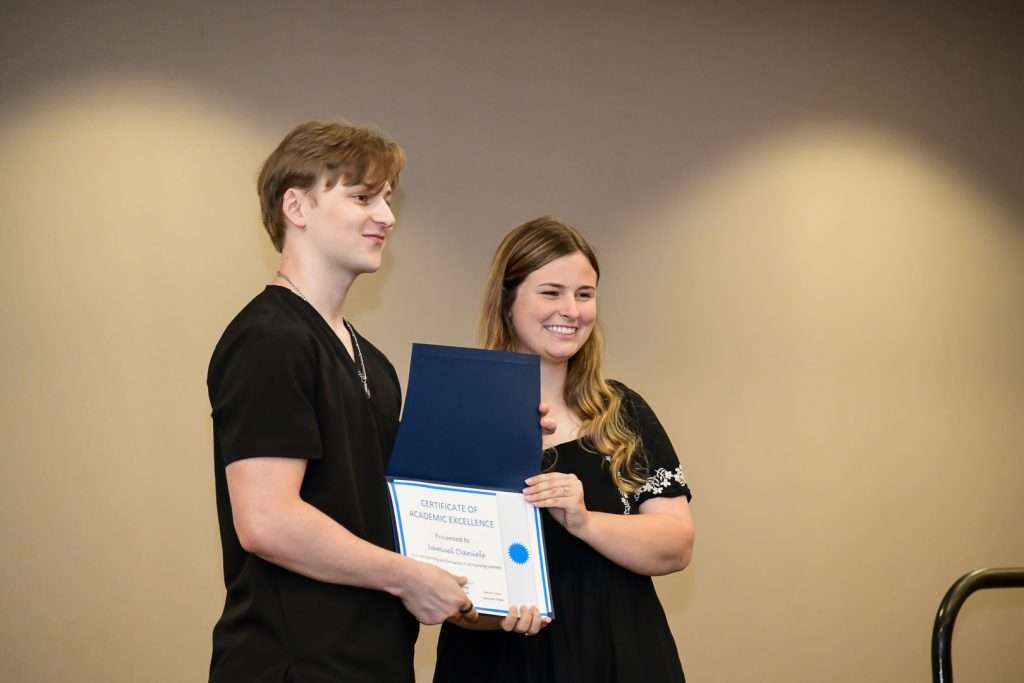 2 people on stage with a certificate