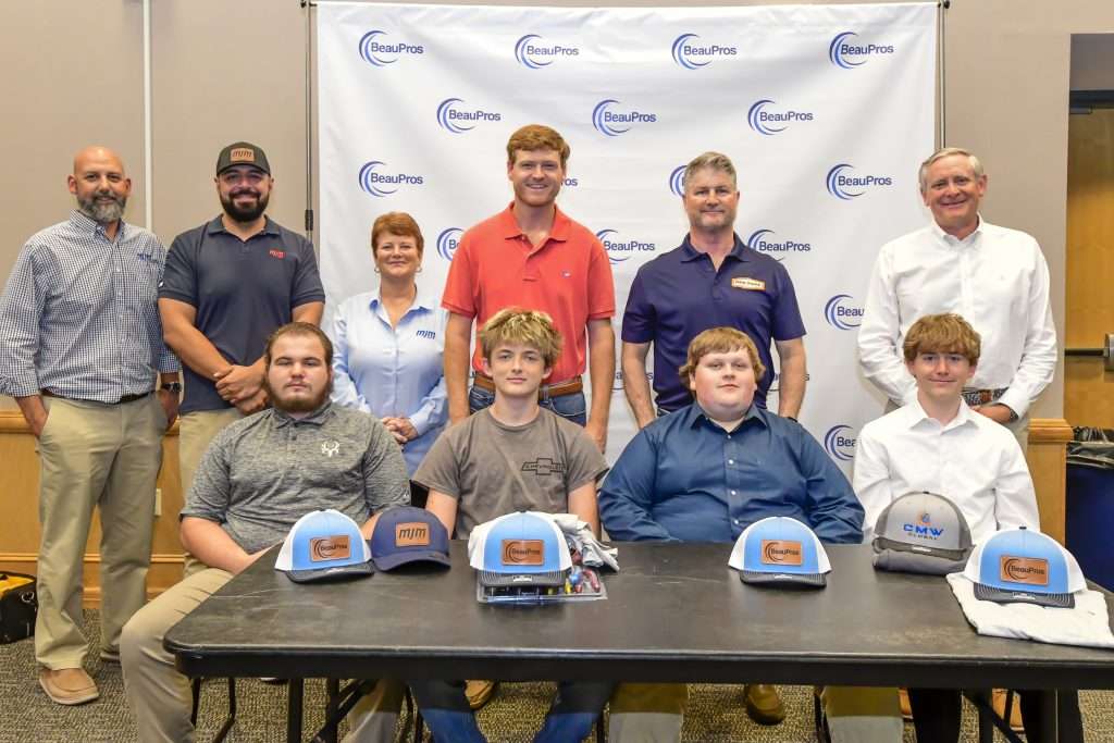 two rows of people, hats on a table